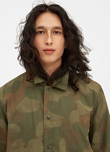 Person wearing collared shirt with a camouflage pattern