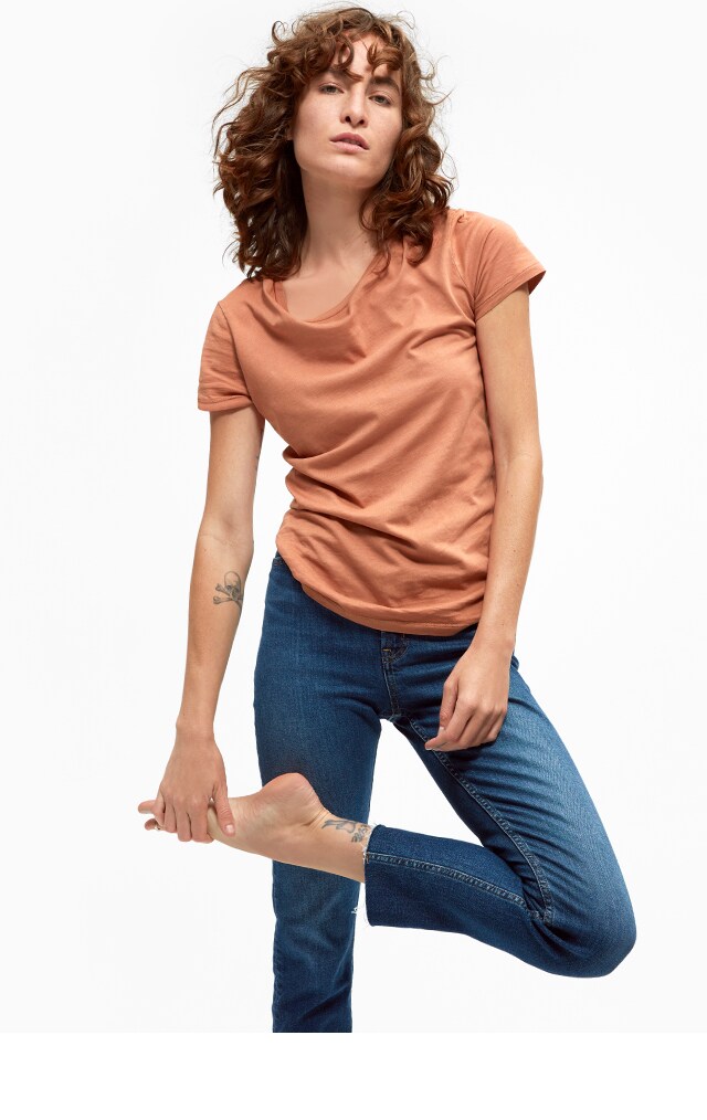 Woman in an orange tee shirt and jeans