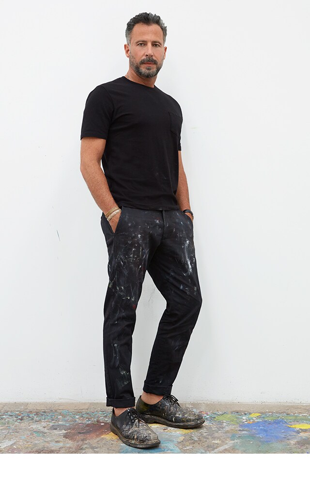 Man wearing a black tee shirt and dark jeans