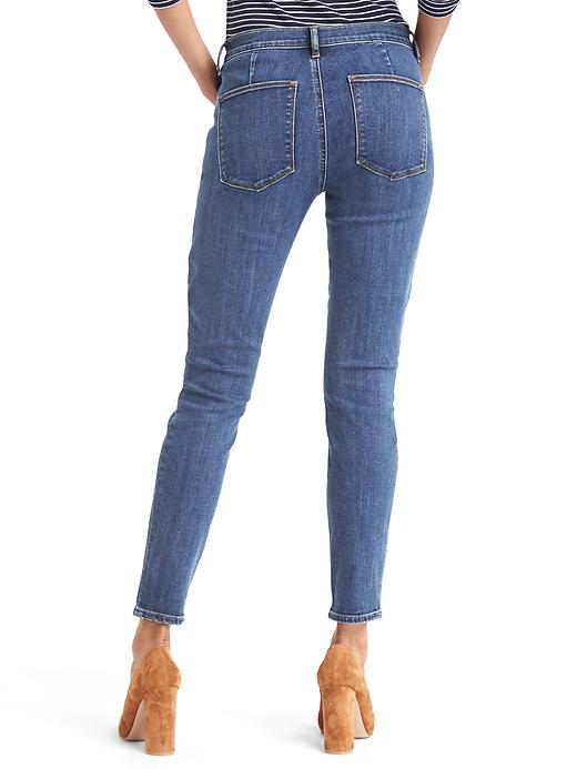 2 of 8 showing, with the color dark indigo of product Mid rise zip pocket true skinny ankle jeans