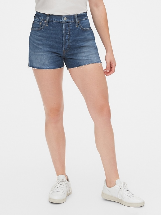 1 of 8 showing, with the color medium indigo of product High Rise Cheeky Denim Shorts with Raw Hem