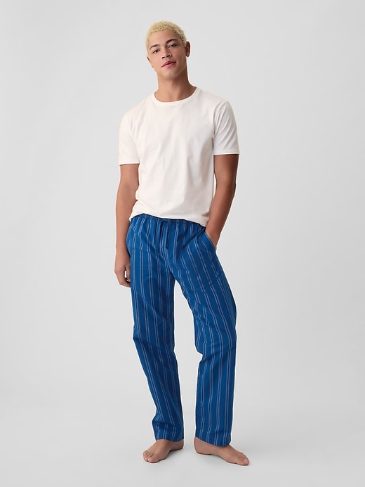 A man wearing blue striped pajama bottoms