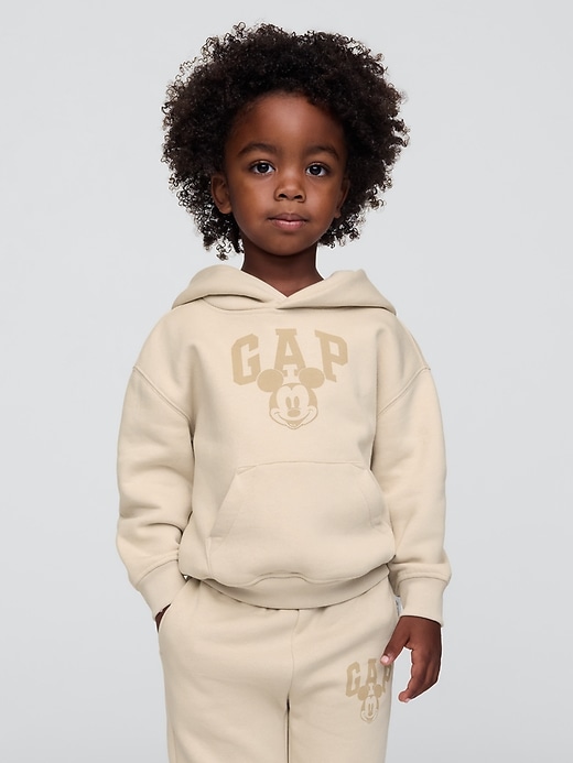 1 of 8 showing, with the color bedrock beige of product Gap × Disney Baby Vintage Soft Mickey Mouse Logo Hoodie